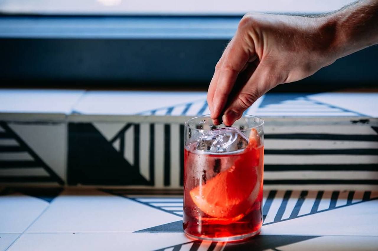 Person garnishing a cocktail